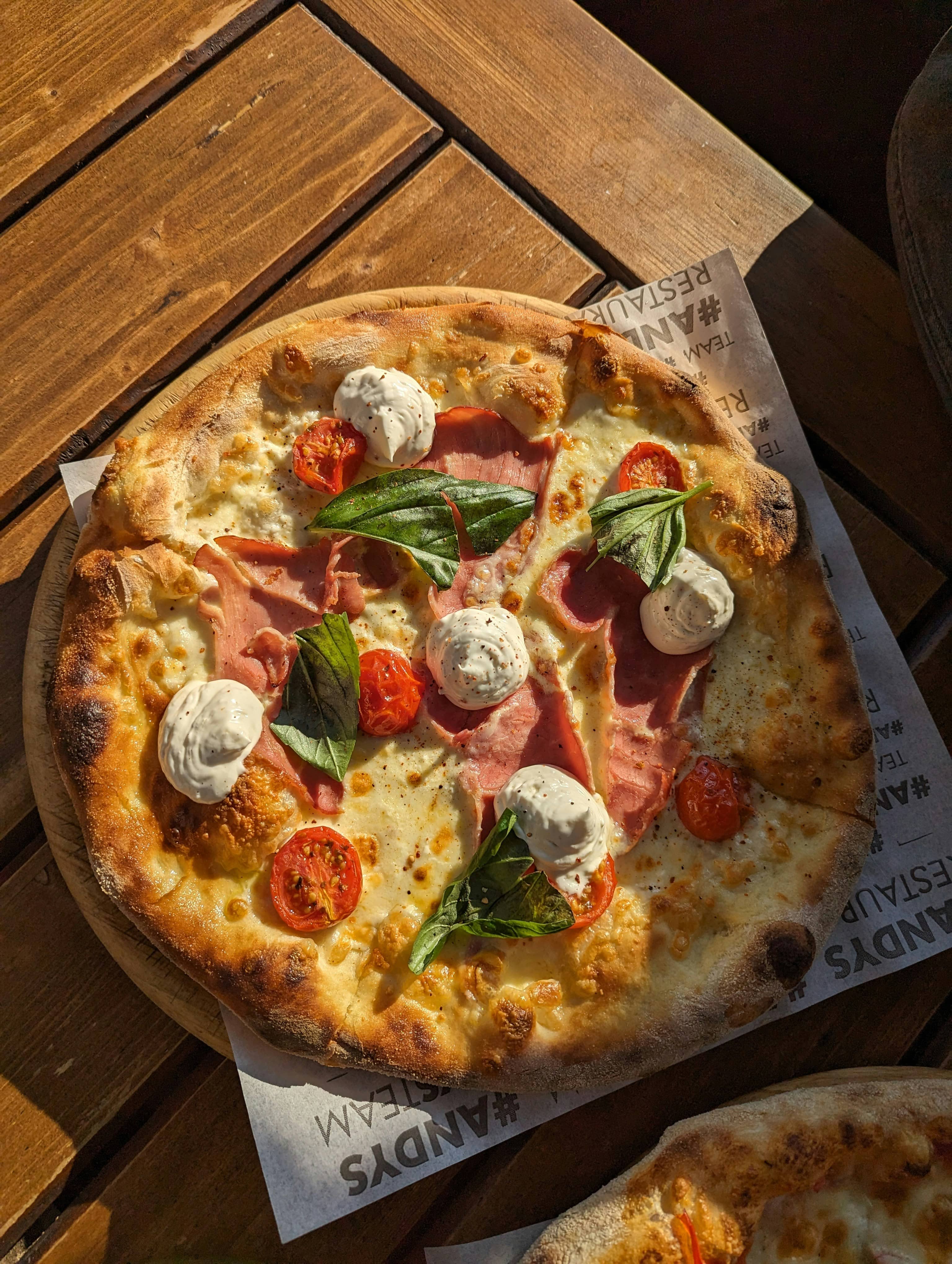 Pizza bianca vista dall'alto con creme fresche e pomodorini confit